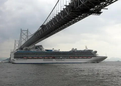 Diamond Princess（Princess Cruises）が大きな橋の下を航行中の外観